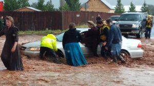 Fire and rescue workers pull a woman from a car in knee-deep flood water in the town of Hildale, Utah, along the Arizona border on Sept. 15, 2015. (Credit: Chris and Lydia Wyler via CNN Wire)