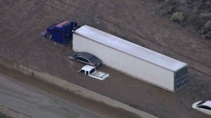 Several vehicles are seen trapped hood-deep in mud following a storm in the Mojave area. (Credit: KTLA)