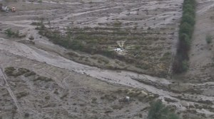 A county fire helicopter responds to areas inundated with mudflows on Oct. 15, 2015. (Credit: KTLA)