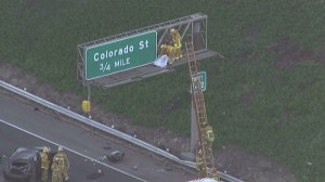 An L.A. firefighter covers the body of a man who was ejected from a vehicle after a crash on the 5 Freeway on Oct. 30, 2015. (Credit: KTLA)