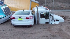 A car came to a rest on top of a partially buried big rig on State Route 58 after severe weather swept through the area on Oct. 16, 2015. (Credit: Kern County Sheriff's Office) 