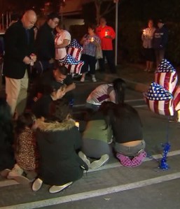 Friends and family members cried openly as they sat on the payment and touched the spot where the young officer died. (Credit: KTLA)
