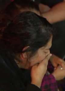 A woman tries to hold back tears at a candlelight vigil for slain Downey Police Officer Ricardo Galvez on Nov. 19, 2015. (Credit: KTLA)