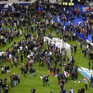 Football fans gather in the field as they wait for security clearance to leave the Stade de France in Saint-Denis, north of Paris, after the friendly football match France vs Germany on November 13, 2015 following shootings and explosions near the stadium and in the French capital. (Credit: FRANCK FIFE/AFP/Getty Images)