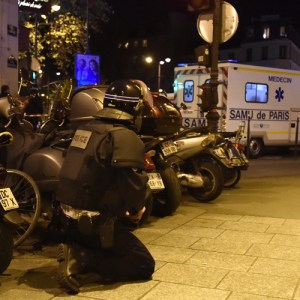 A riot police officer stands by an ambulance near the Bataclan concert hall in central Paris, on November 13, 2015. (Credit: DOMINIQUE FAGET/AFP/Getty Images)