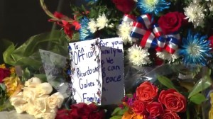 Flowers and a card are seen Nov. 19, 2015, at Downey police station in honor of Officer Ricardo Galvez, who was killed the previous night. (Credit: KTLA)