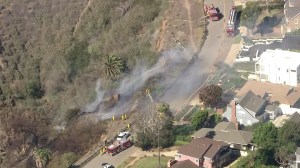 LAFD battles a fire near homes in Pacific Palisades on Nov. 10, 2015. (Credit: KTLA)