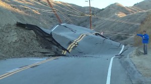 KTLA reporter Mark Mester stands next to Vasquez Canyon Road, which continued to buckle on Nov. 20, 2015. (Credit: KTLA)