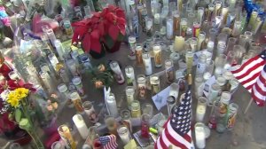 Candles and American flags were included in a growing memorial dedicated to the victims of a deadly shooting in San Bernardino on Dec. 2, 2015. (Credit: KTLA)