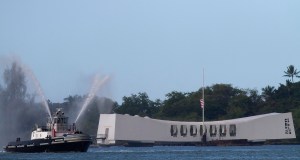 A tugboat fires water cannons near the Arizona Memorial during a memorial service for the 70th anniversary of the attack on the U.S. naval base at Pearl Harbor. (Credit: Kent Nishimura/Getty Images)