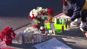 A mourner on Dec. 16, 2015, leaves a candle near the site where Andres Perez was killed the previous day. (Credit: KTLA)