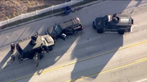 Authorities surround a heavily damaged SUV in San Bernardino on Dec. 2, 2015. (Credit: KTLA)