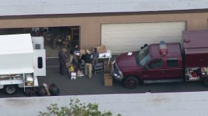 Investigators work on Dec. 3, 2015, in the garage area of a Redlands home rented by the couple who opened fire in San Bernardino the previous day. (Credit: KTLA)