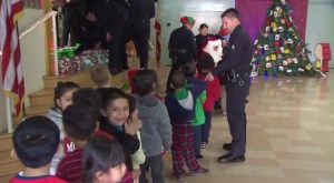 Children wait in line at Selma Avenue Elementary during an LAPD Christmas visit on Dec. 18, 2015. (Credit: KTLA)