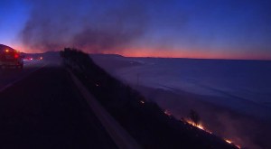 The Solimar Fire is pictured as the sun rises over the 101 Freeway in Ventura County on Dec. 26, 2015. (Credit: KTLA)