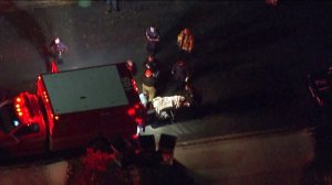 A person is seen being placed into the back of an ambulance in West Hills on Dec. 11, 2015. (Credit: KTLA)