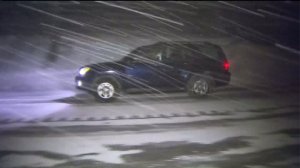 An SUV drives amid snowfall in the Big Bear area on Jan. 4, 2016. (Credit: KTLA)