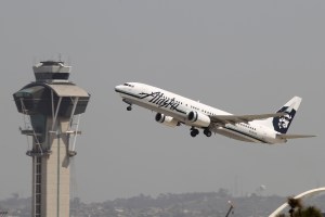 An Alaska Airlines jet passes the air traffic control tower at Los Angles International Airport during take-off on April 22, 2013. (Credit: David McNew/Getty Images)