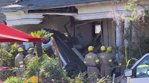 Two people were killed, including a female occupant whose body was trapped, when a vehicle crashed into a Boyle Heights home on Feb. 7, 2016. (Credit: KTLA)