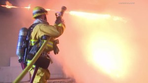 A firefighter battles flames at Theodore Roosevelt High School on Feb. 3, 2016. (Credit: Loudlabs News)