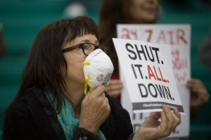 Sue Francis holds a sign while attending a public hearing before the South Coast Air Quality Management District regarding a proposed stipulated abatement order to stop a nearby massive natural gas leak, on Jan. 16, 2016, in Granada Hills. (Credit: David McNew/Getty Images)