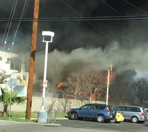 Flames and smoke emanated from an abandoned motel in Van Nuys on Feb. 14, 2016. (Credit: Jon Sklaroff)