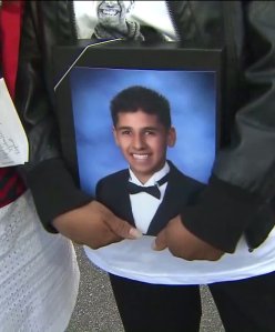 Anthony Macias' mother holds a photo of the deceased teenager during a memorial in Upland on March 13, 2016.