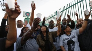 Ruth Harlins, center, in scarf, grandmother of Latasha Harlins, and other family and community members raise candles in memory of Latasha on the 25th anniversary of her shooting death along Figueroa Street in Los Angeles. (Credit: Genaro Molina)