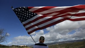 Simi Valley resident Andy Hall honors the late Nancy Reagan with an American flag by the road to the Ronald Reagan Presidential Library in Simi Valley. (Credit: Francine Orr / Los Angeles Times)