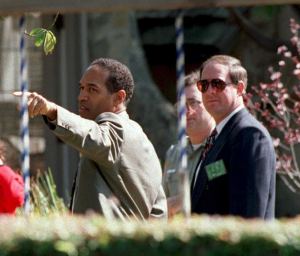 Murder defendant O.J. Simpson, left, points during a tour of his Rockingham estate in Brentwood on Feb. 12, 1995. (Credit: Haywood GALBRAITH/AFP/Getty Images)