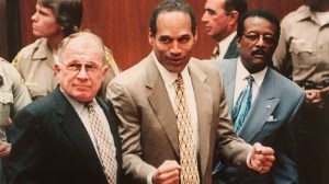 Defendant O.J. Simpson, center, cheers while standing with his attorneys F. Lee Bailey, left, and Johnnie Cochran Jr right, after hearing the not guilty verdict in his criminal murder trial in Los Angeles on Oct. 3, 1995. (Credit: Agence France Presse/Getty Images)