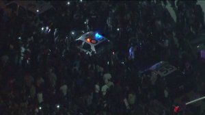 Several protesters swarm a Costa Mesa police car and try to overturn it following a Trump rally on April 28, 2016. (Credit: KTLA)