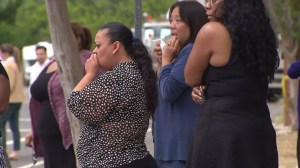 Coworkers of a woman killed in a West Hills crash visit the site on April 12, 2016. (Credit: KTLA)