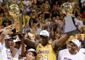 Shaquille O'Neal of the Los Angeles Lakers holds the MVP trophy and the Larry O'Brien Trophy for winning the NBA Championship 19 June, 2000, after game six of the NBA Finals at Staples Center in Los Angeles. (Credit: Vince Bucci/AFP/Getty Images)