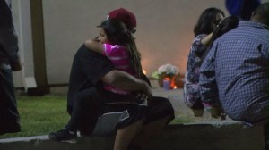 Mourners comfort each other outside Ulysses S. Grant Elementary School on April 12, 2016, when a sixth-grader died. (Credit: KTLA)