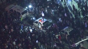 Someone jumps on a police car at an anti-Trump protest outside a campaign rally in Costa Mesa on April 28, 2016. (Credit: KTLA)