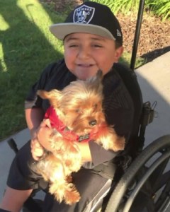 Juan Hernandez, 10, and his service dog Buddy are seen in a photo provided by his family.