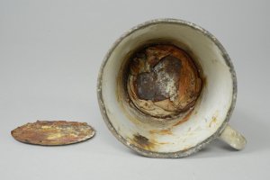 A mug confiscated by Nazis at Auschwitz has been hiding a secret for more than 70 years. Workers at the Auschwitz Museum this week found a gold ring and necklace that had been carefully wrapped in canvas before being concealed in a false base. (Credit: Auschwitz Museum)