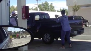 A still from a video posted May 17, 2016, shows a woman beating a man's truck in Lancaster. (Credit: Monet Dansereau and Boogie Fressh)