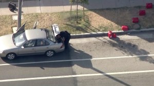 An LAPD bomb squad member searches a car linked to the UCLA shooter found in Culver City on June 3, 2016. (Credit: Sky5)