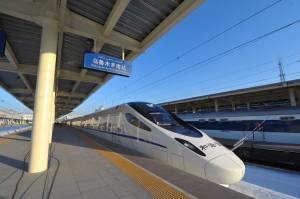 A bullet train stops at the platform before it travels to Lanzhou from the Urumqi south railway station in Urumqi, northwest China's Xinjiang region on December 26, 2014. (Credit: STR/AFP/Getty Images)