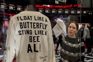 Curator Shannon Pratt, 37 polishes a case containing a signed 'Float like a butterfly sting like a bee' robe worn by cornerman Bundini Brown at the 'Rumble in the Jungle' fight. (Credit: Chris Ratcliffe/Getty Images)