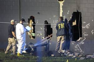 FBI agents investigate near the damaged rear wall of the Pulse nightclub where a gunman killed at least 50 people on June 12, 2016, in Orlando, Florida. (Credit: Joe Raedle/Getty Images)