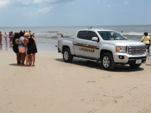 Lifeguards respond to the search for a missing teen swimmer in Myrtle Beach, South Carolina, on June 16, 2016. (Credit: Brad Jones/WGHP)