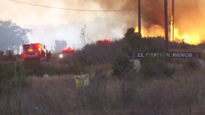 Fire burns behind an El Capitan Ranch sign. (Credit: KTLA) 