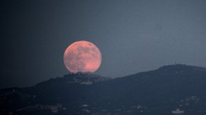 A rising moon is seen over the city of Rome on June 23, 2013. (Credit: FILIPPO MONTEFORTE/AFP/Getty Images)