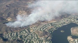 Plumes of smoke rise above Lake Sherwood on July 13, 2016, during a brush fire that burned 78 acres. (Credit: KTLA)