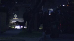 Sheriff's deputies stand next to a man lying on the ground at the scene of a deputy-involved shooting on July 28, 2016. (Credit: KTLA)
