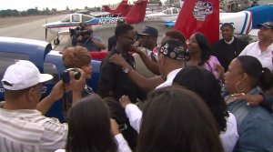 After a group prayer, Isaiah Cooper gets a hug before his departure from Compton airport on July 5, 2016. (Credit: KTLA)