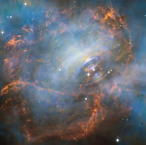 NASA's Hubble Space Telescope captured this image of the Crab Nebula and its "beating heart," which is a neutron star at the right of the two bright stars in the center of this image. The neutron star pulses 30 times a second. The rainbow colors are visible due to the movement of materials in the nebula occurring during the time-lapse of the image. (Credit: NASA / ESA)